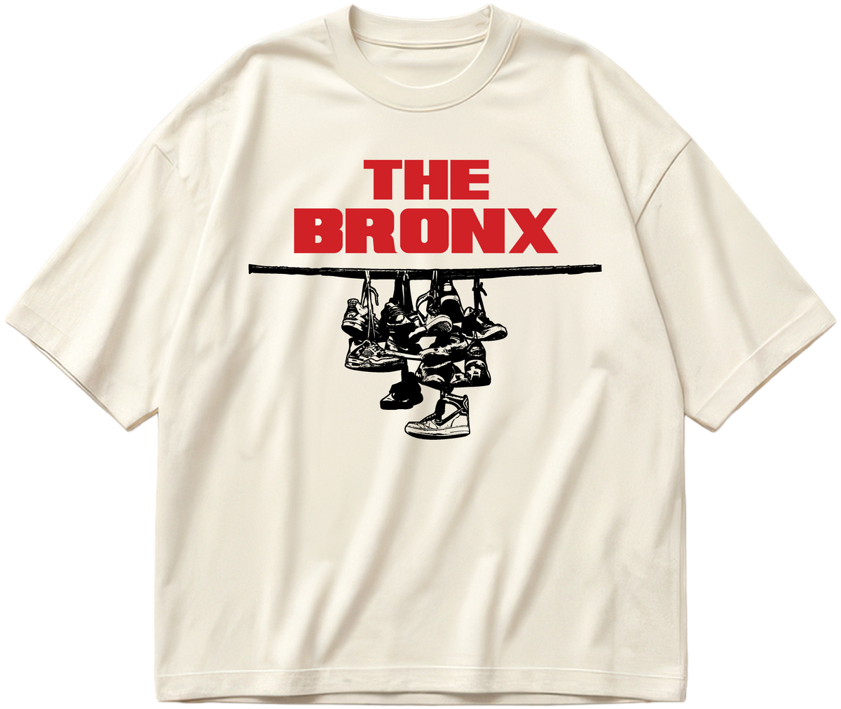 Off-white oversized Sneaker Hang tee with red The Bronx lettering above a black hanging-sneakers design.