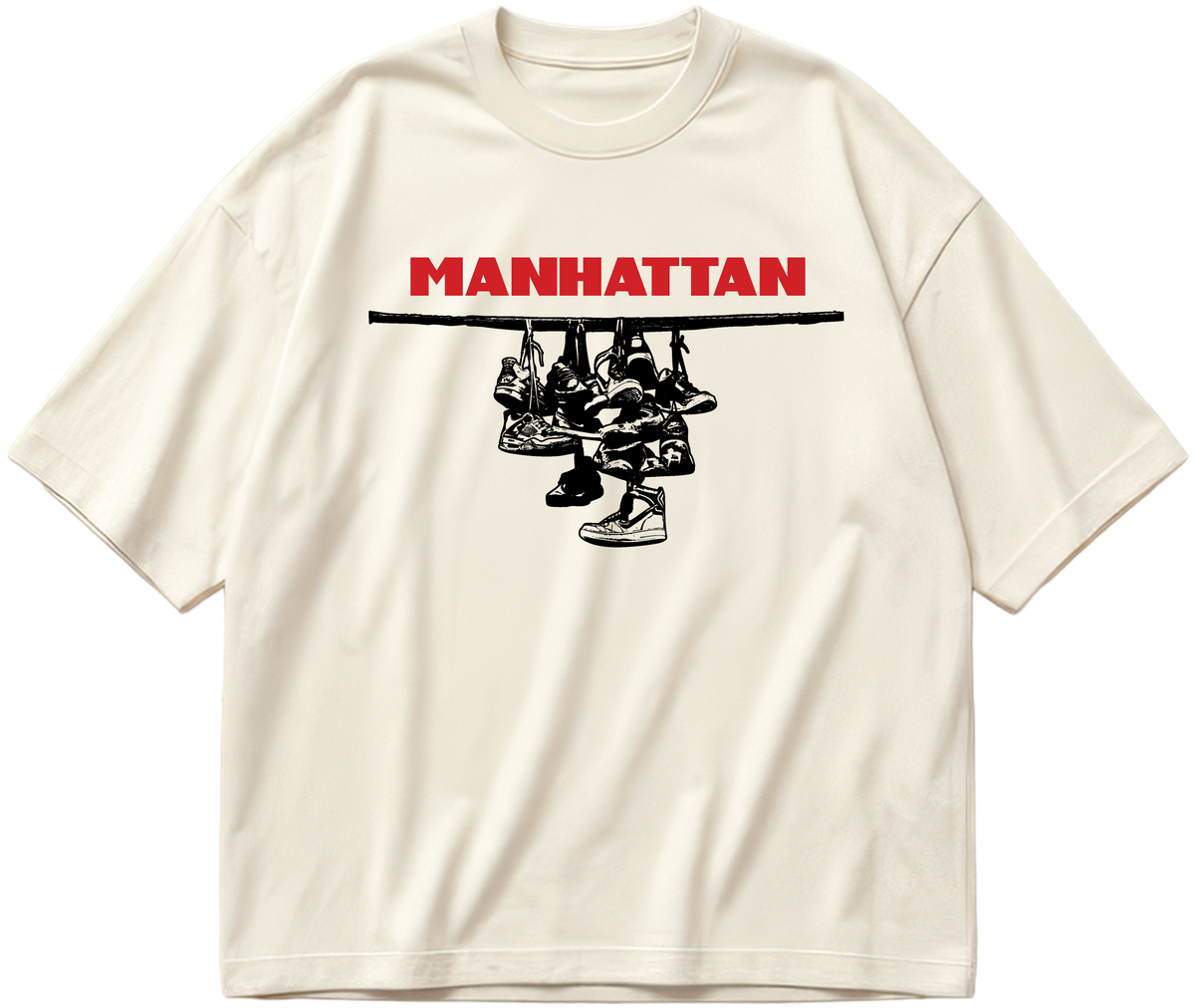 Off-white oversized Sneaker Hang tee with red Manhattan lettering above a black hanging-sneakers design.