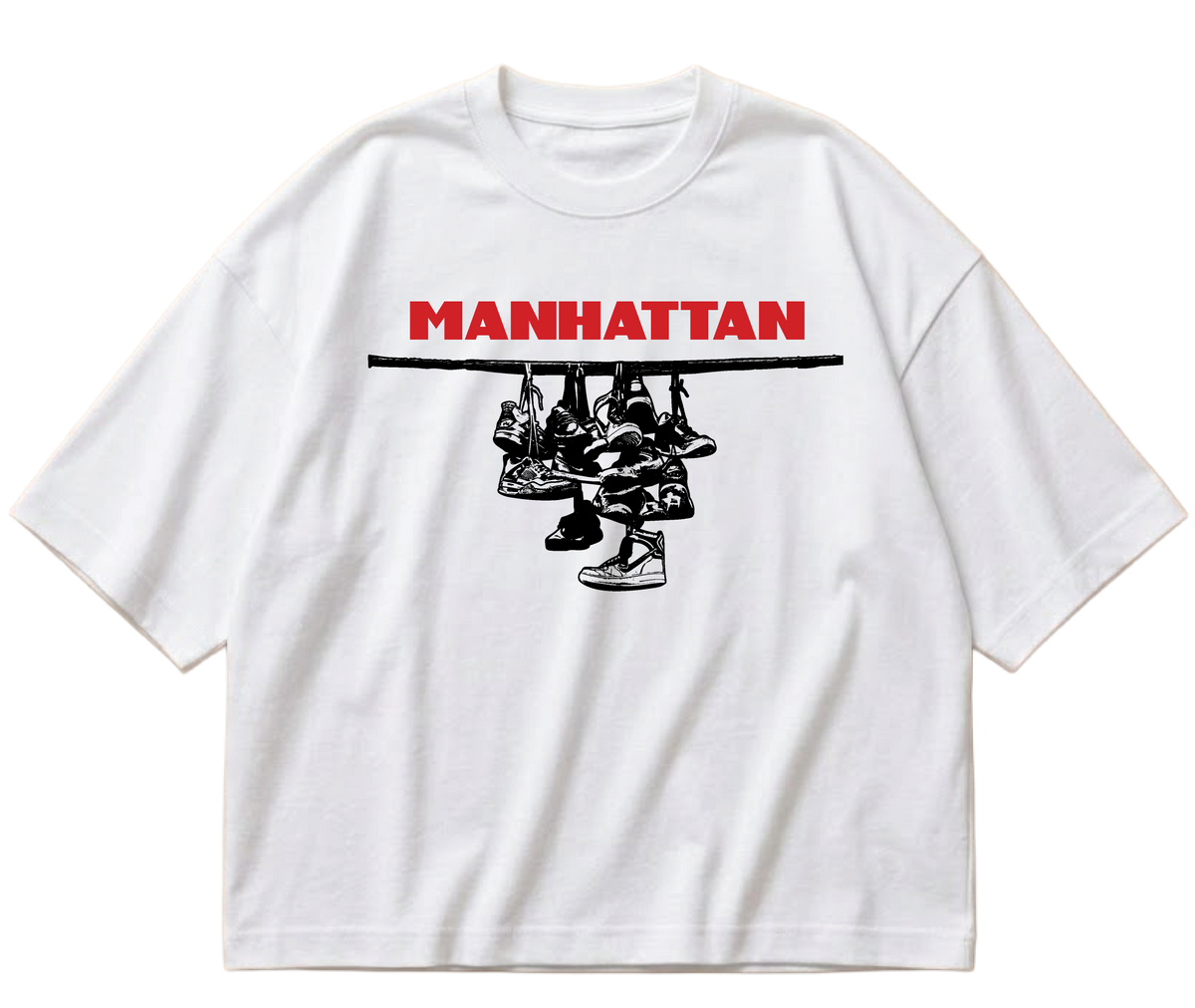 White boxy cropped Sneaker Hang tee with red Manhattan lettering above a black hanging-sneakers design