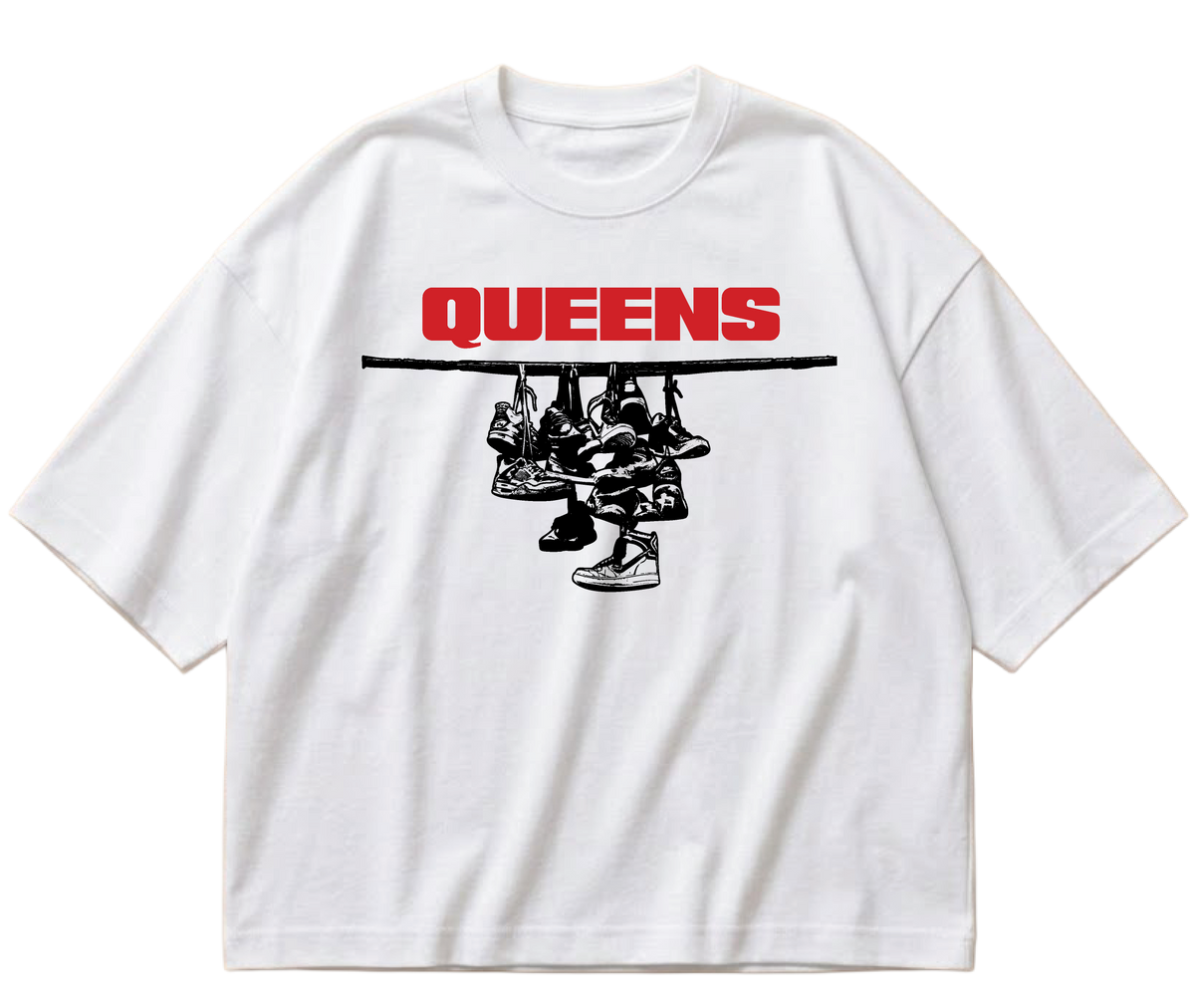 White boxy cropped Sneaker Hang tee with red Queens lettering above a black hanging-sneakers design.